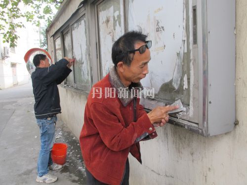 徐宝根（右）在社区义务清理小广告