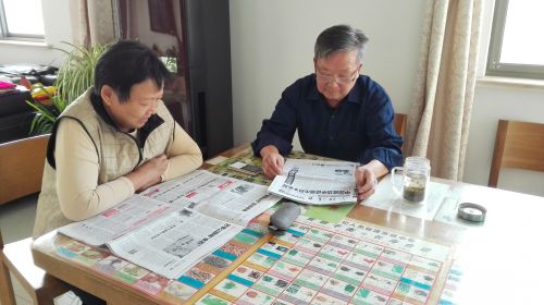 朱青青和丁金洪夫妻俩闲来无事看报纸