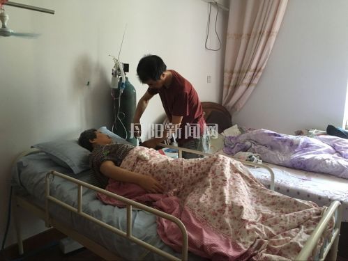 丁锁平在床边照料妻子1