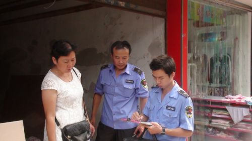 图为城管执法人员在依法整治市容（中为裔双福）