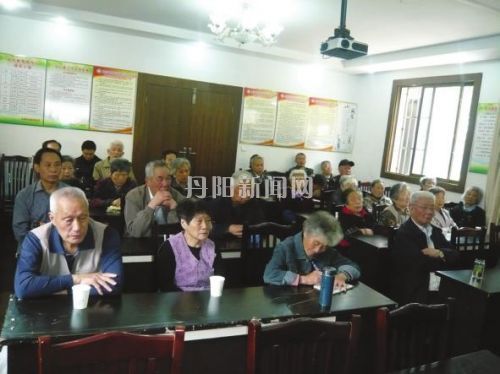 朱奶奶（一排右二）参加社区会议时认真做着笔记。
