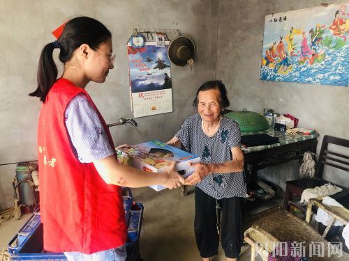 二条图片：工作人员将水蜜桃送给老人。记者 李潇 摄影