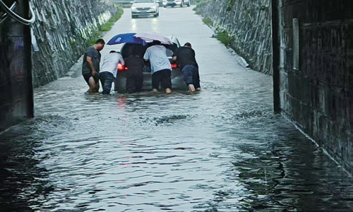 暴雨下涵洞成“险境” 村干部合力推车救人