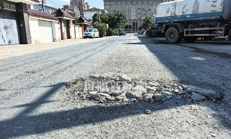 百米道路坑洼密布，车辆行人“闯关”难行