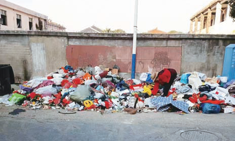 围墙外成垃圾场 环卫工义务清理