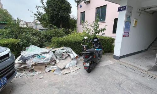 建筑垃圾乱堆，车辆挤占步道
